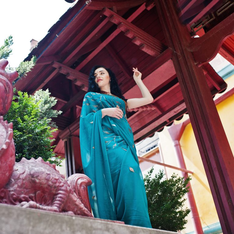 Portrait of beautiful indian brumette girl or hindu woman model against japanese traditional house and dragon figure.